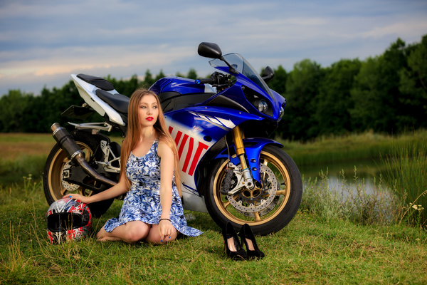 Girl and motorbike sitting on the grass Stock Photo