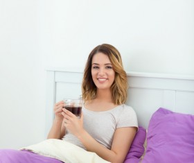Girl drinking coffee in bed Stock Photo