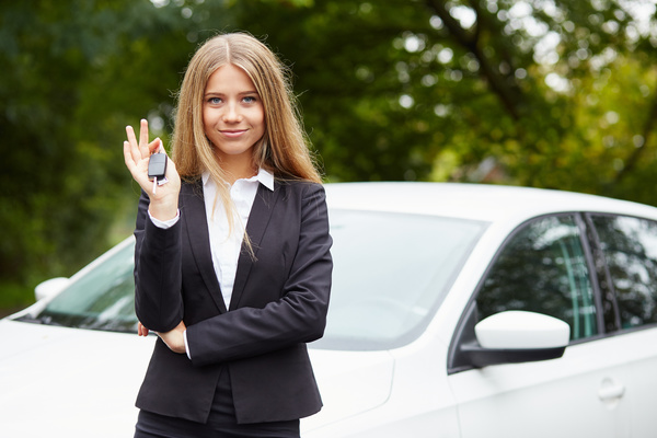 Girl holding car key in front of the car Stock Photo 02