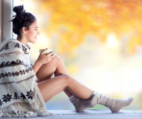 Girl holding coffee and looking out the window Stock Photo
