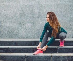 Girl tying shoes on the steps Stock Photo