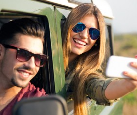 Girl with cell phone selfie outside car window Stock Photo