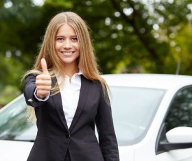Girl with thumbs up in front of the car Stock Photo