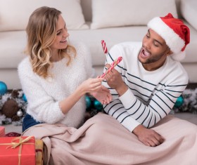 Happy couple holding a Christmas candy Stock Photo