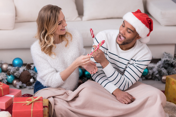 Happy couple holding a Christmas candy Stock Photo