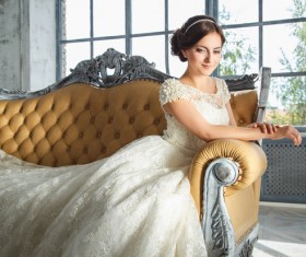 Happy smiling bride sitting on the couch Stock Photo