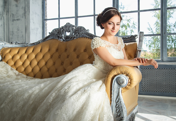 Happy smiling bride sitting on the couch Stock Photo