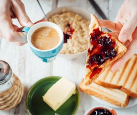 Holding coffee and a slice of bread with jam Stock Photo