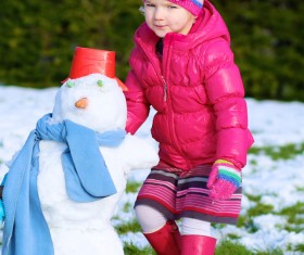 Little girl making snowman Stock Photo
