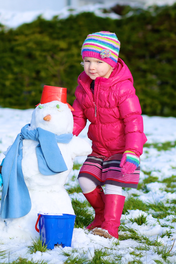 Little girl making snowman Stock Photo