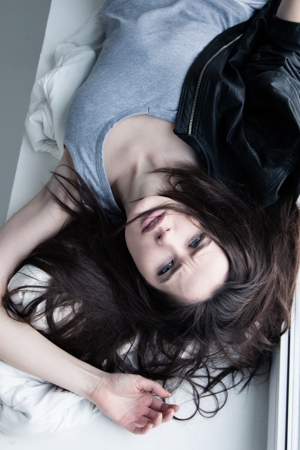 Lying in bed frowning girl Stock Photo