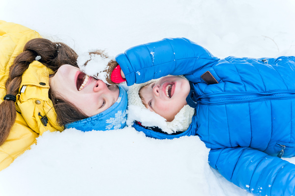 Mother and little boy lying on the snow Stock Photo