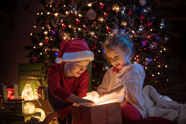 Open presents on Christmas Eve children Stock Photo