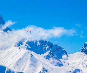 Parachute sports on cloudy snowy mountain Stock Photo