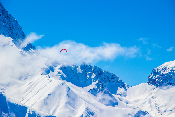 Parachute sports on cloudy snowy mountain Stock Photo