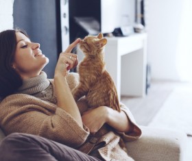 Sitting on the couch woman and pet cat Stock Photo