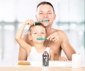 Smiling child brushes his teeth with dad Stock Photo 01
