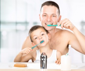 Smiling child brushes his teeth with dad Stock Photo 02