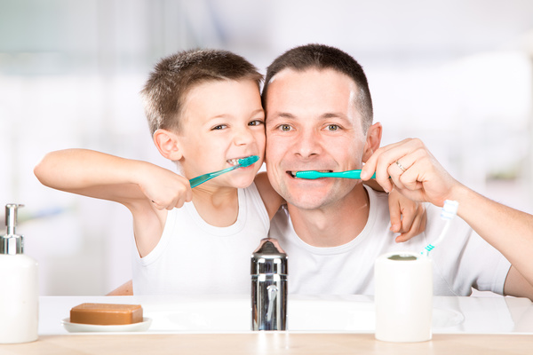 Smiling child brushes his teeth with dad Stock Photo 04