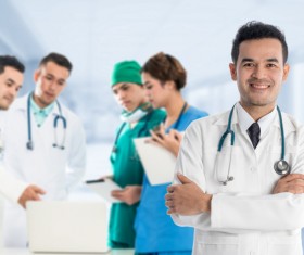 Smiling male doctor and medical team Stock Photo