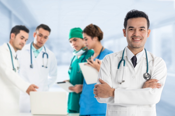 Smiling male doctor and medical team Stock Photo