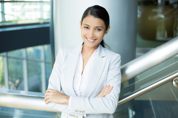 Smiling woman standing on stairs Stock Photo