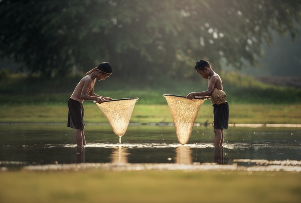 Southeast Asian children who catch fish in small rivers Stock Photo
