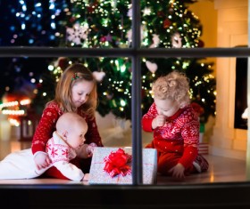 Three siblings looking at Christmas gifts Stock Photo