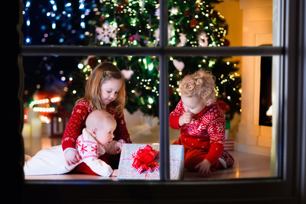 Three siblings looking at Christmas gifts Stock Photo