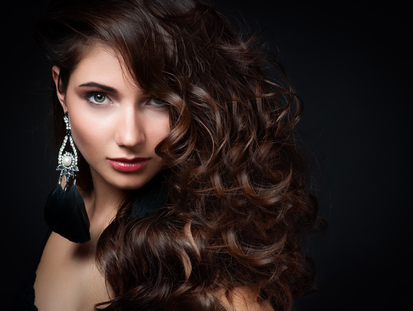 Woman with long curly hair wearing earrings Stock Photo