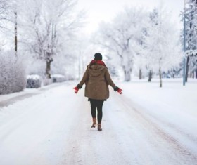 Women walking on snow covered roads Stock Photo