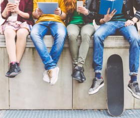 Young man sitting bridge bar reading book playing cell phone Stock Photo