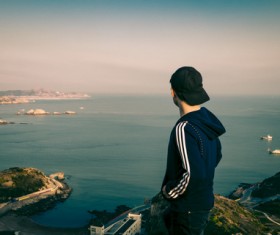 Young man watch sea scene on mountain Stock Photo