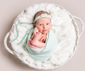 Baby lying in basket playing Stock Photo 01