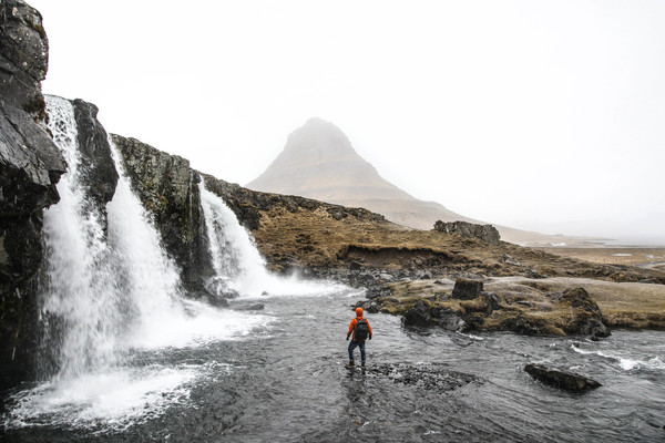 Backpacker exploring natural waterfall landscape Stock Photo