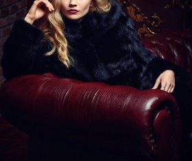 Blonde girl in black mink coat sitting on the couch Stock Photo 01