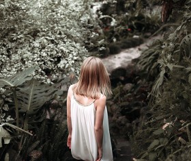 Blonde girl walking in the garden Stock Photo