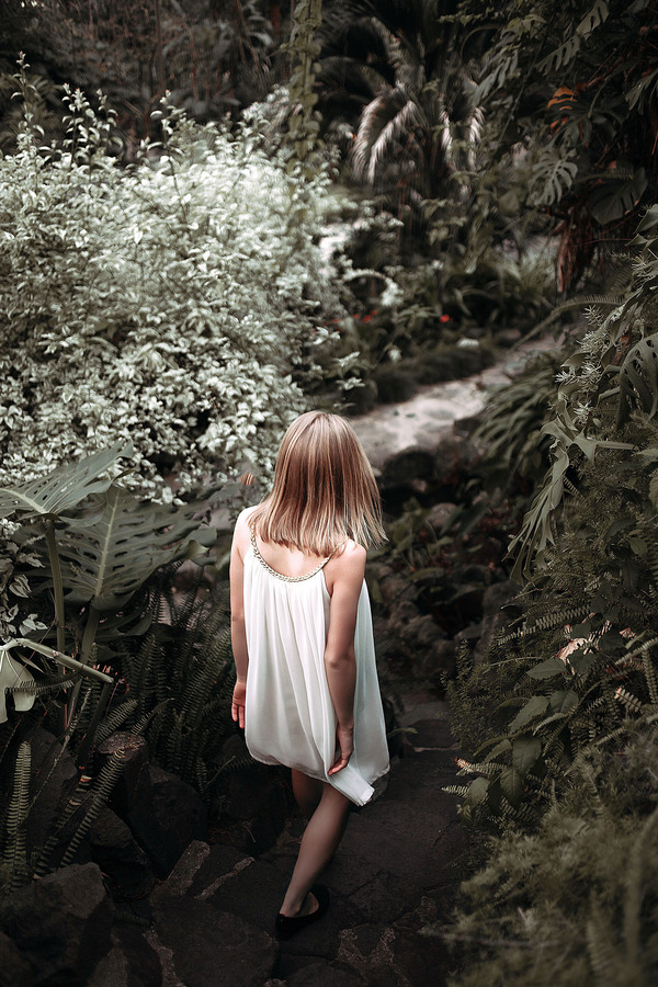Blonde girl walking in the garden Stock Photo