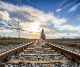 Carrying musical instrument girl walking on the tracks Stock Photo