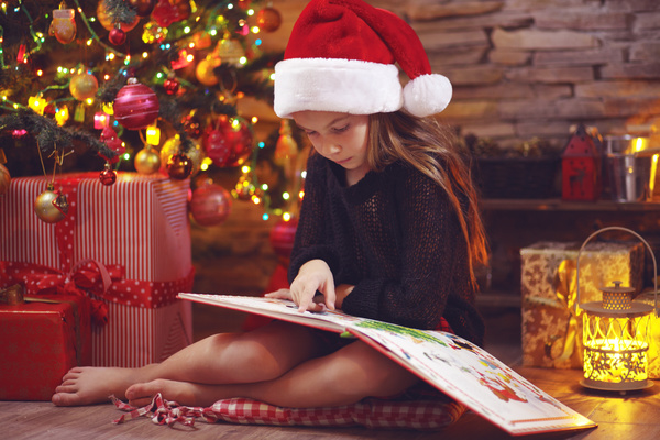 Christmas little girl reading comic book Stock Photo