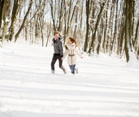 Couple running in winter snow outdoors Stock Photo