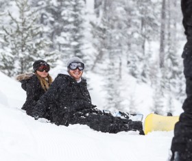Couple sitting in the snow happy Stock Photo