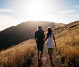 Couple walking in the mountains in the sunshine Stock Photo