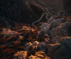 Curved road on rocky mountain landscape at dusk Stock Photo