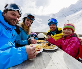 Family who enjoy lunch at the ski slopes Stock Photo