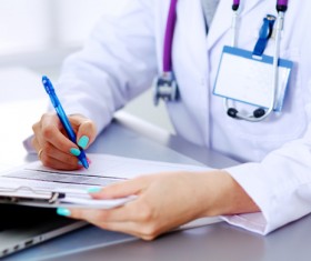 Female doctor writing medical records Stock Photo