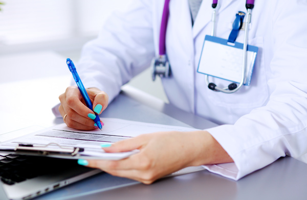 Female doctor writing medical records Stock Photo