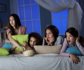 Girls gathered together watching TV Stock Photo