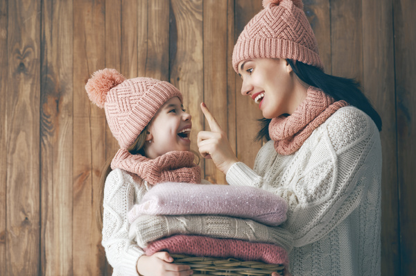 Happy mother and daughter wearing knitted sweaters Stock Photo