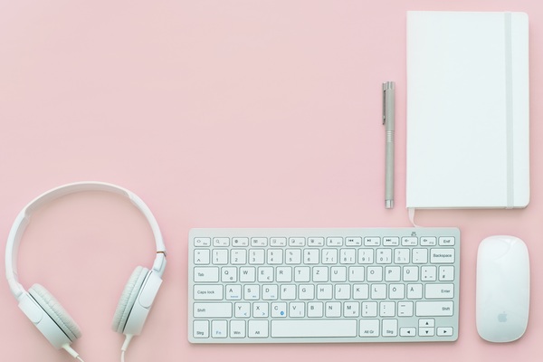Headphone keyboard on pink desktop Stock Photo